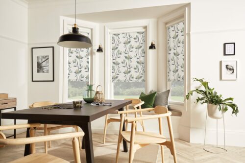 A modern dining room with bay window fitted with perfect fit floral blinds.