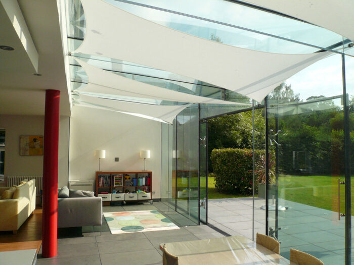 Shade sails in a glass room extension